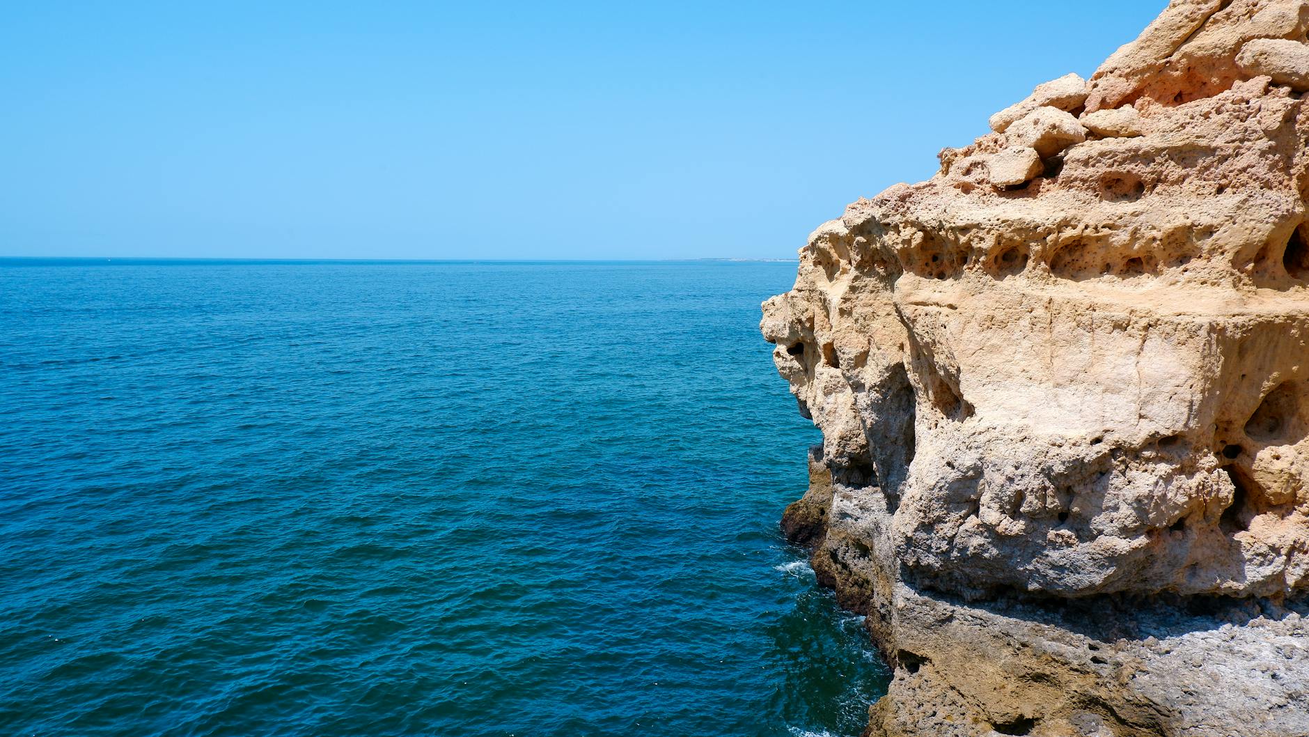 Klify wapienne Algarve nad turkusowym Atlantykiem w słoneczny dzień