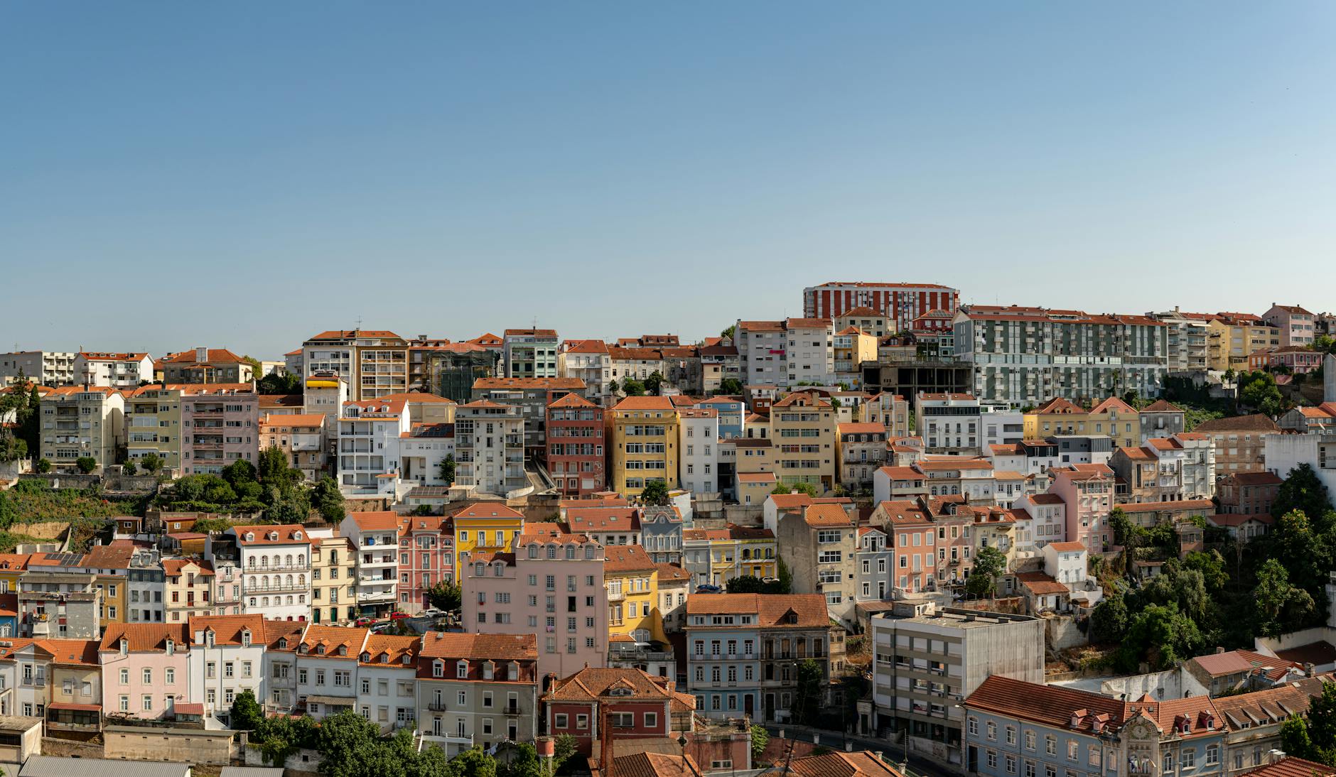 Panorama kolorowych zabudowań na wzgórzu w Coimbrze za dnia