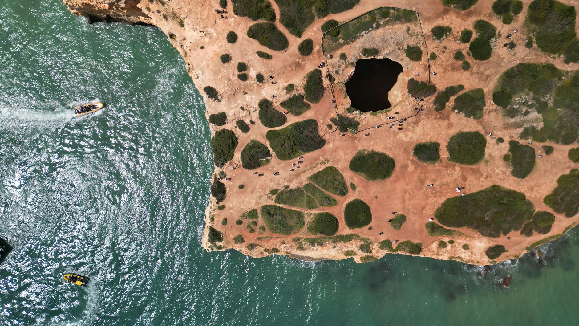 Klify Algarve z naturalną jaskinią nad turkusową wodą z lotu ptaka