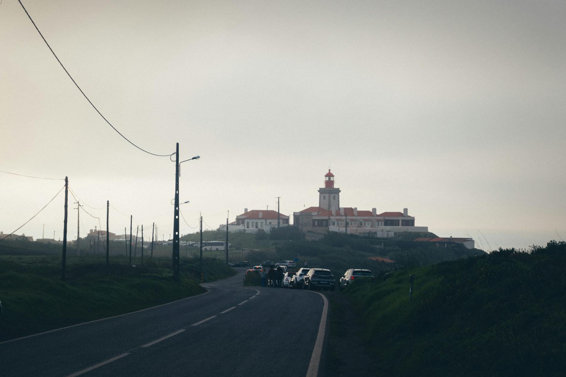 Latarnia Cabo da Roca we mgle nad krętą portugalską szosą