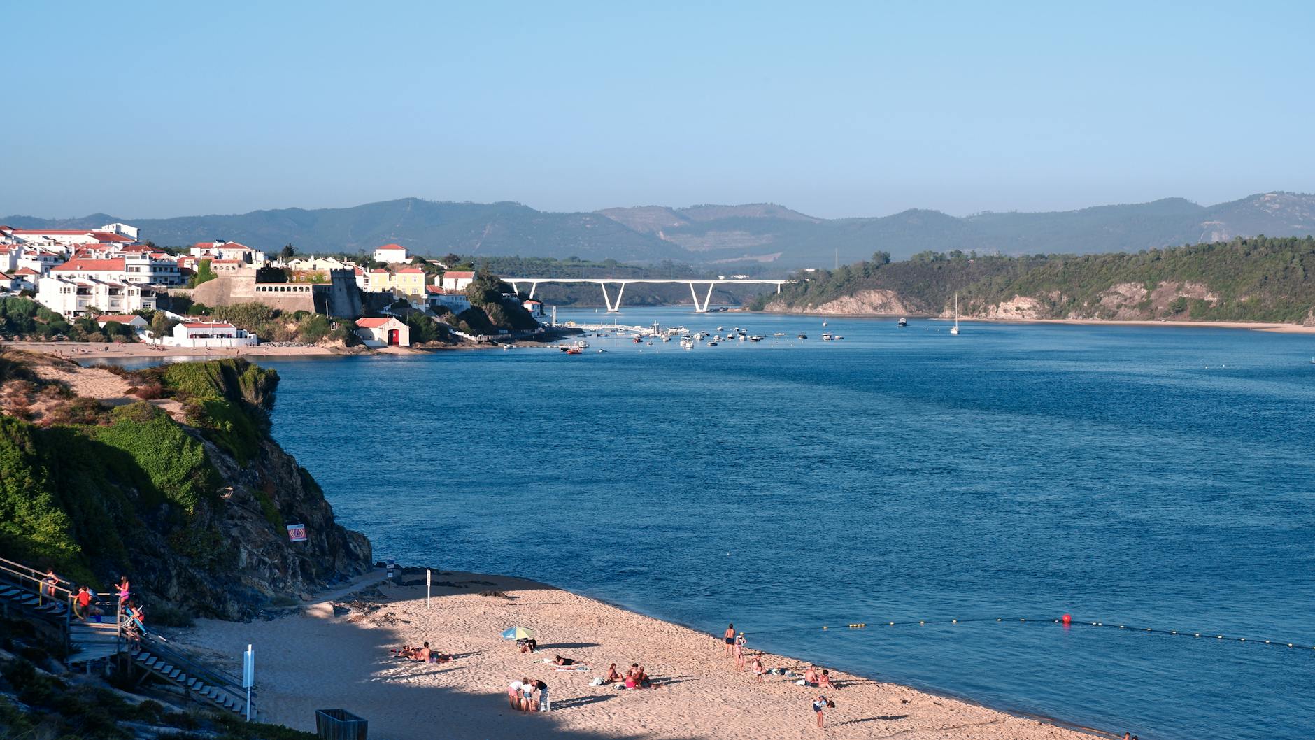 Plaża i most w Vila Nova de Milfontes w słoneczny dzień