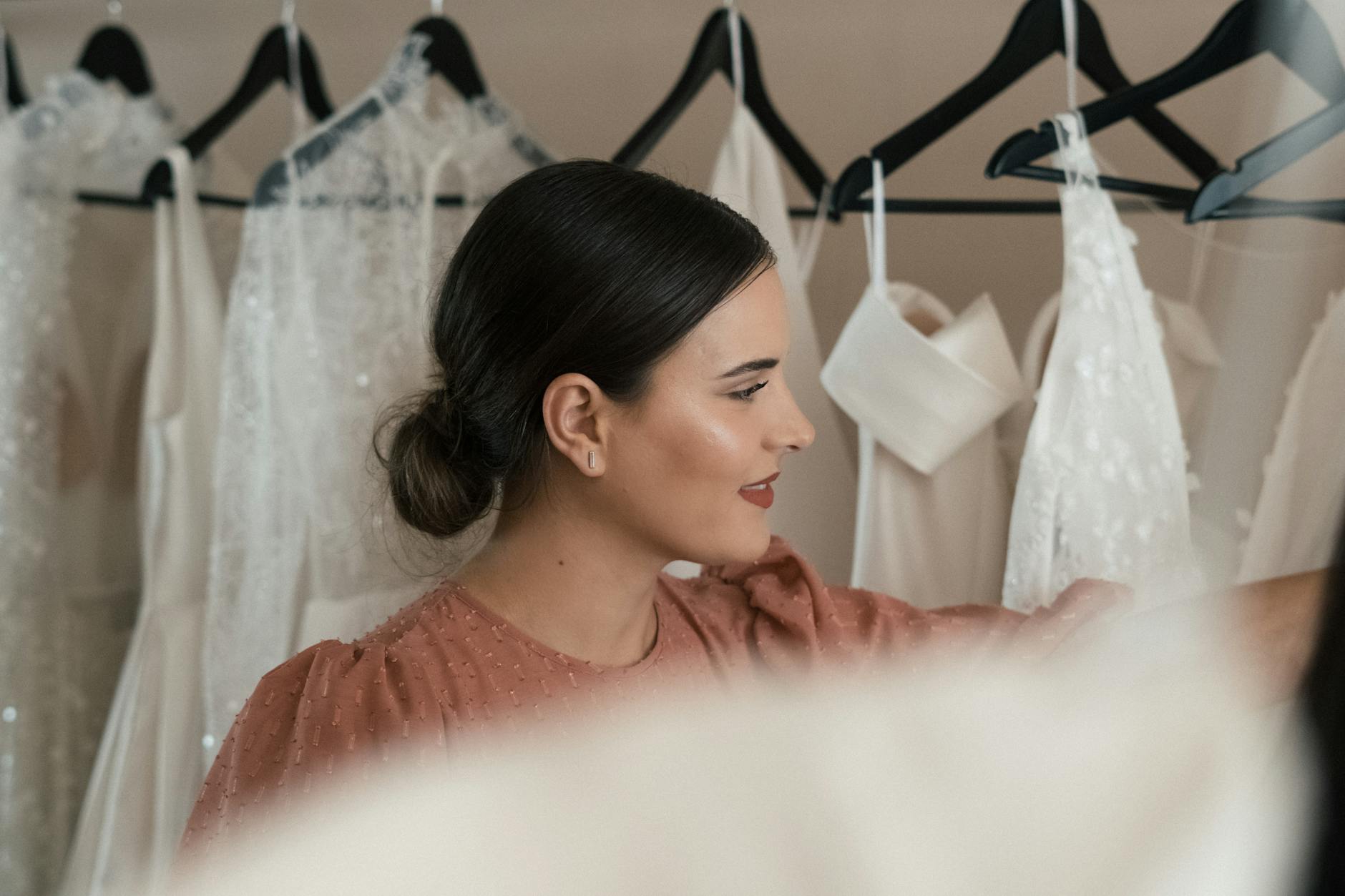 Przyszła panna młoda wybiera suknię ślubną w eleganckim salonie Przyszła panna młoda wybiera suknię ślubną w eleganckim salonie