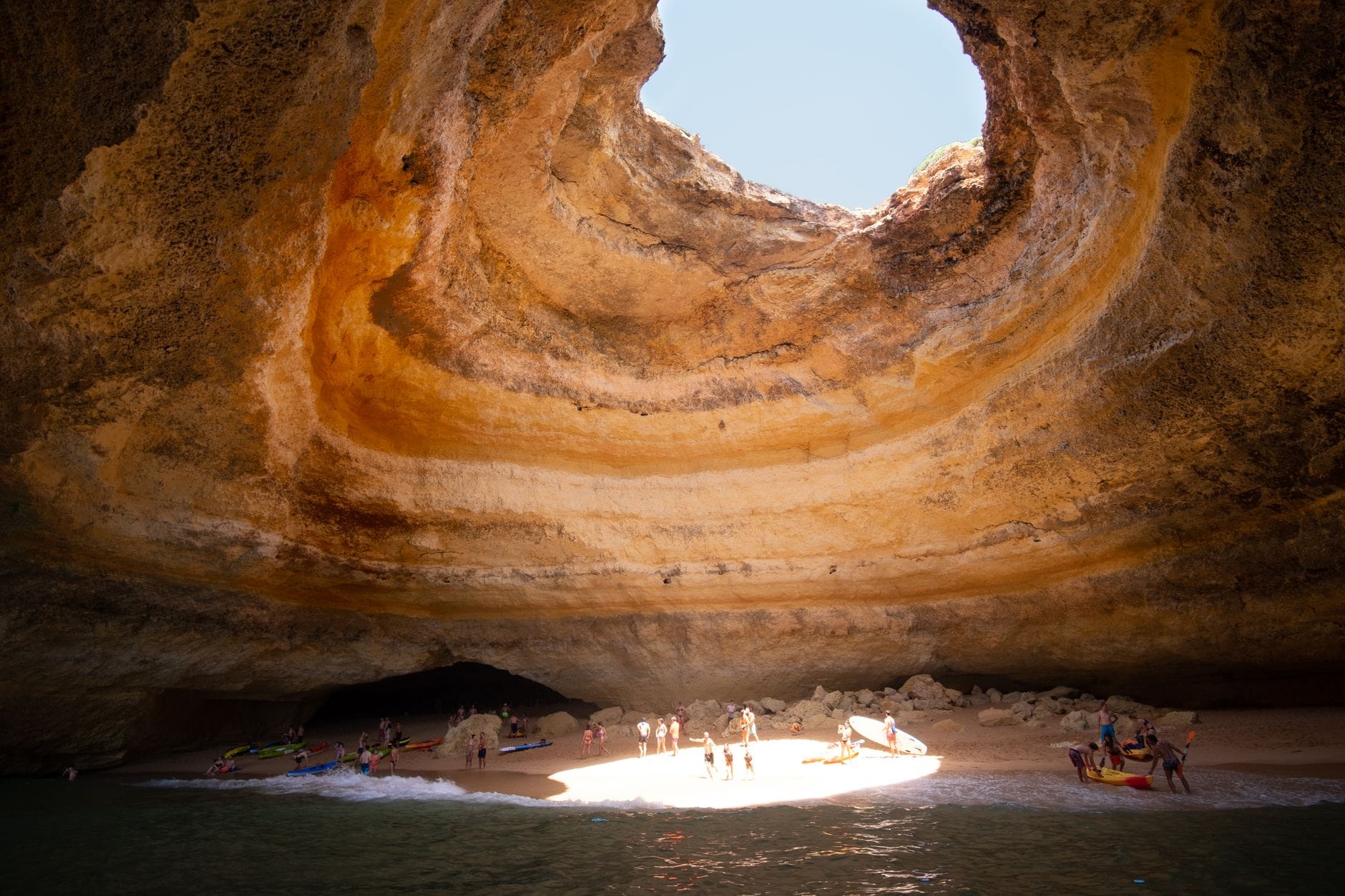 Jaskinia Benagil w Algarve z oświetloną słońcem piaszczystą plażą