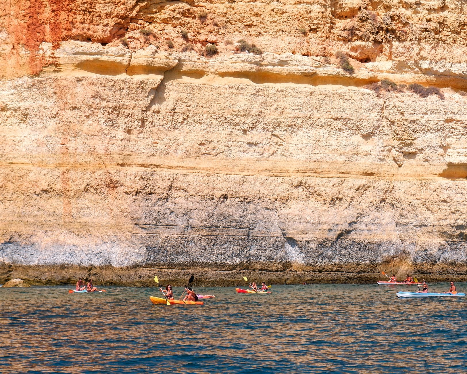 Kajakarze płyną wzdłuż klifowego wybrzeża Algarve
