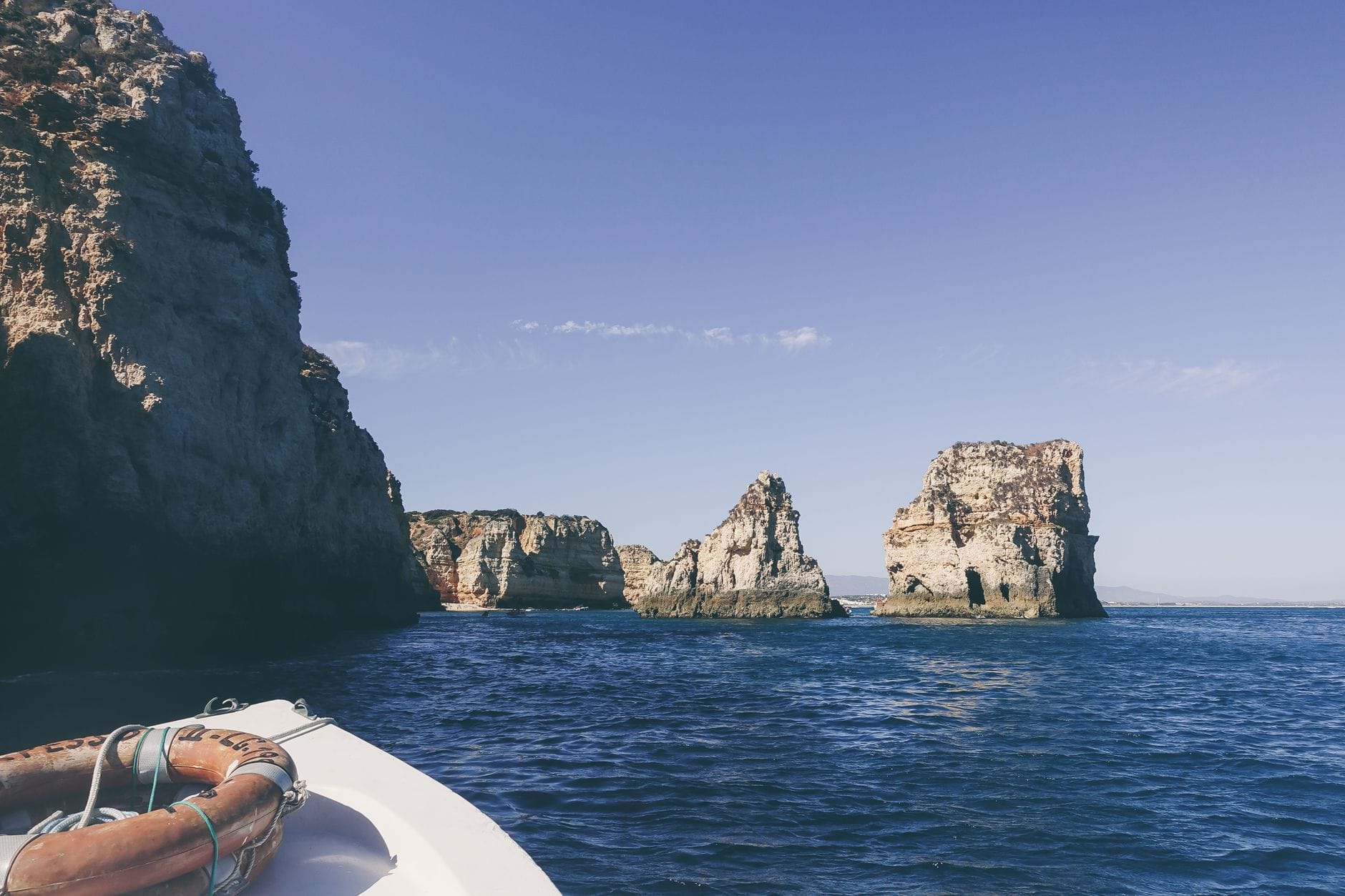 Klify Algarve nad spokojnym oceanem widziane z łodzi
