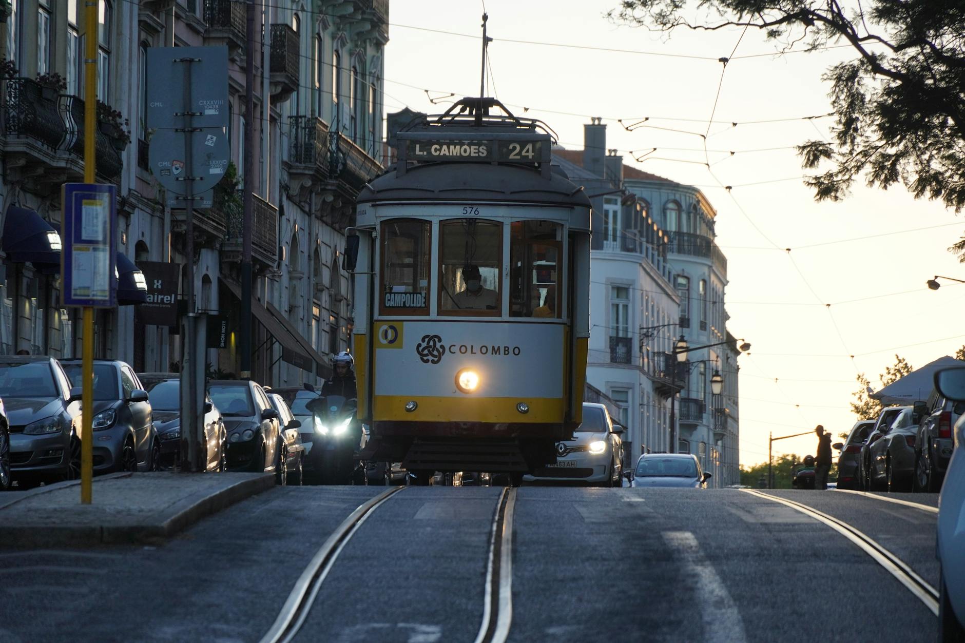 Tramwaj 28 jedzie wśród zabytkowych kamienic Lizbony o zachodzie słońca