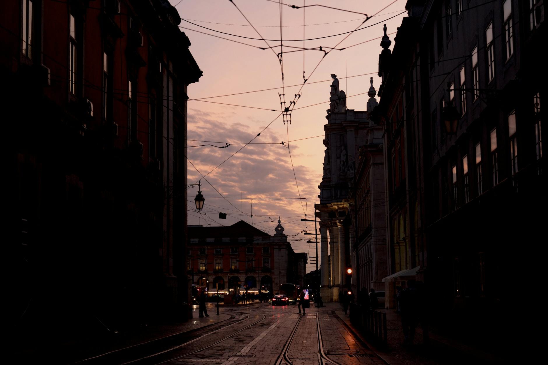 Ulica Lizbony o zmierzchu z liniami tramwajowymi na tle nieba
